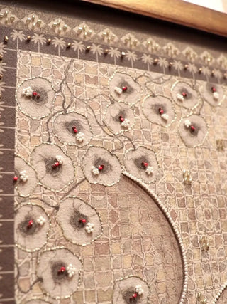 Close-up video of The Birds of Anqa embroidered wall art in Sand & Sage, moving over beaded blossoms, a bird in flight, a palm tree and zellige arches