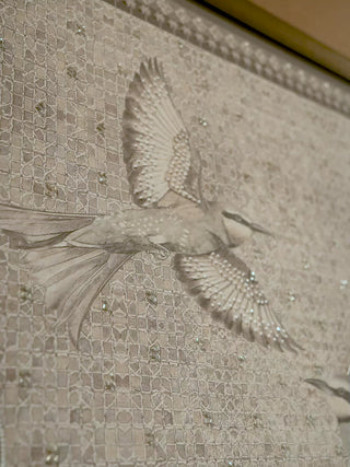 The Birds of Anqa embroidered wall art in silver-grey: a bird in flight, a beaded bird among palms and a zellige-pattern background