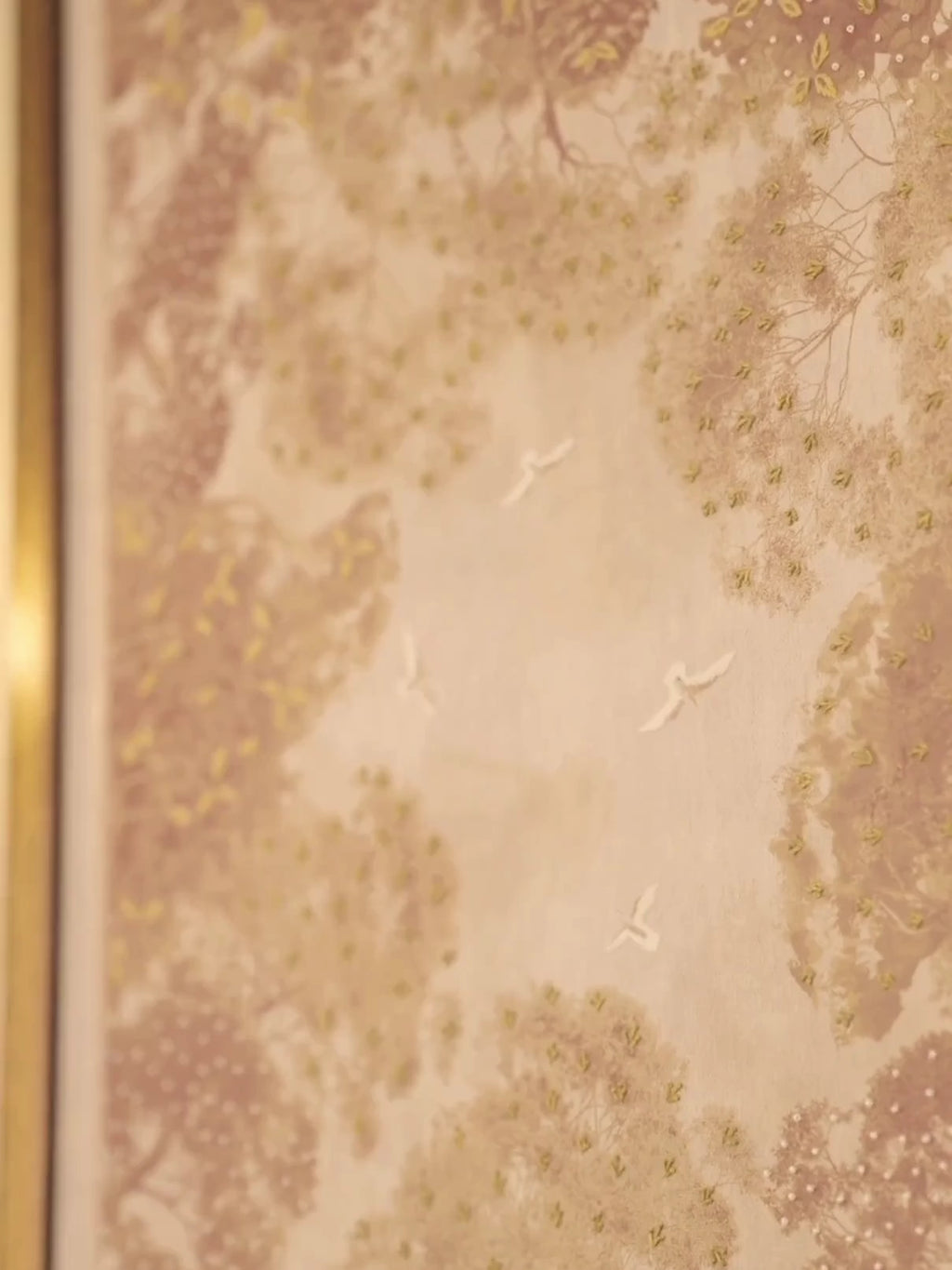Close view of The Forest Nest wall art in gold and burgundy, then the framed print above a cream sofa between brass wall sconces
