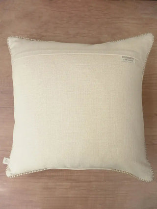 The reverse side view of the Prose Pattern cushion cover showing the clean fabric backing, hidden zipper closure, and brand woven tag.