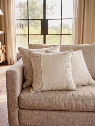 A cluster of Prose Pattern paneled linen cushion covers styled elegantly across a plush contemporary taupe sofa layout.