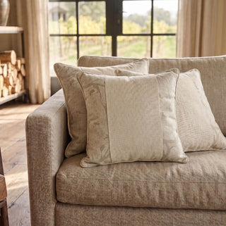 A cluster of Prose Pattern paneled linen cushion covers styled elegantly across a plush contemporary taupe sofa layout.