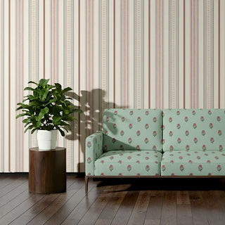 Sofa upholstered in Pulkit Fabric featuring mint green base with repeating floral butis against striped wallpaper.