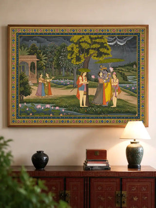 The Radha Krishna wall art framed and installed above a red lacquered console table with a ceramic lamp and vase in a living room view-livingroom