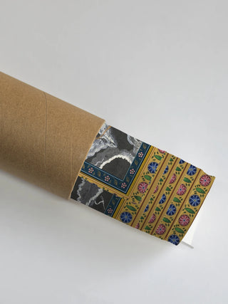 The Radha Krishna wall art print rolled and partially unrolled inside a protective kraft shipping tube with the floral border visible