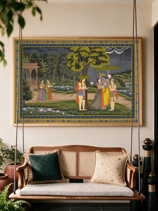The Radha Krishna wall art framed and installed above a hanging rattan swing bench with quilted cushions in a reading nook view-nook