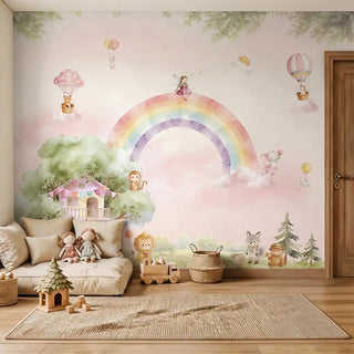 A hand-painted watercolor rainbow mural featuring a treehouse and forest animals in a luxury nursery with a floor sofa and jute rug.
