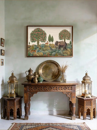 Rajasi Van wall art framed above a carved wooden console table styled with brass lanterns and a vintage water jug.