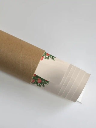 A close-up of the Rajasi Van wallpaper partially unrolled from its shipping tube, showcasing the pomegranate tree and forest details.