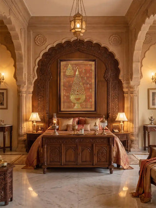 Rajghrana wall art in rust and gold, framed in dark wood within a carved scalloped arch above a teak bed with silk bedding and brass lamps in a bedroom.