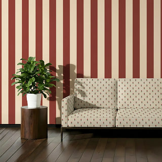 Modern sofa upholstered in Rakt Pushp Fabric with repeating red floral patterns against beige, styled with bold red and cream striped wallpaper.
