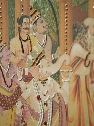 Close up of Ram Abhishek embroidered wall art showing the raised pearl strands, gold beadwork and studded pillar detail around the white elephant and attendants