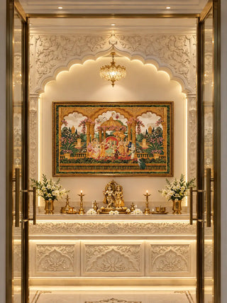Ram Abhishek embroidered wall art in an ornate gold frame, showing a golden domed pavilion in a flowering palace garden, hung above a brass lamp ledge in a carved white marble prayer niche with a scalloped arch.