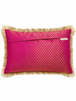 The reverse of the Rangrez cushion cover in pink brocade with a gold diamond lattice, an overlap closure, a brand label and gold fringe edges.