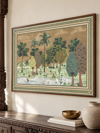 An angled view of the Ranthambore forest landscape wall art in a wood frame, hung above a carved console with brass and ceramic accents.