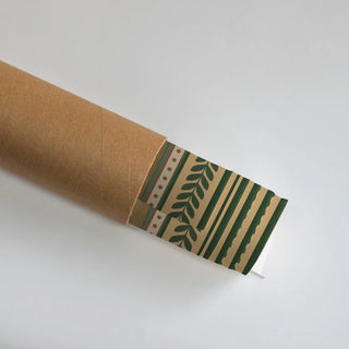The Ranthambore Forest wall art print partially unrolled from its kraft paper shipping tube, showing a dotted border trim beside a leafy branch motif and scalloped green stripes in green, tan and rust.