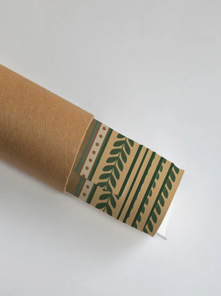 The Ranthambore Forest wall art print partly unrolled from its shipping tube, showing a dotted trim, a leafy green branch border and green stripes on tan.