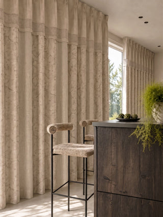 The Reed Rhythm custom linen-blend jacquard curtain panels creating a soft, textured floor-to-ceiling backdrop inside a luxury modern kitchen dining hall.
