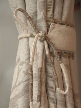 A high-resolution close-up detail of The Reed Rhythm curtain panel highlighting its hand-knotted and wrapped oatmeal rope tieback.