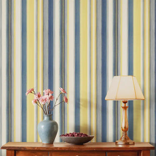 Regal Blue & Yellow striped wallpaper styled behind a wooden console with lamp and vase, adding brightness and elegance.