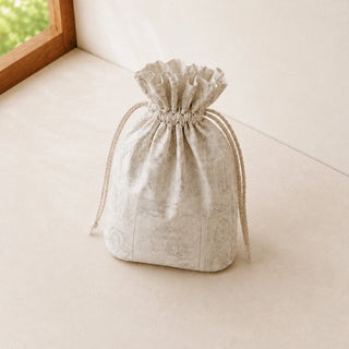 Ivory printed drawstring gift pouch styled alongside the Regal Gilt beaded tiebacks