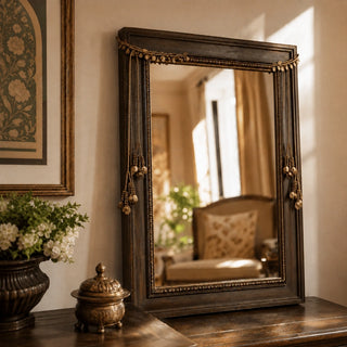 Regal Gilt beaded tassels draped over the top corners of a wooden framed mirror on a console table