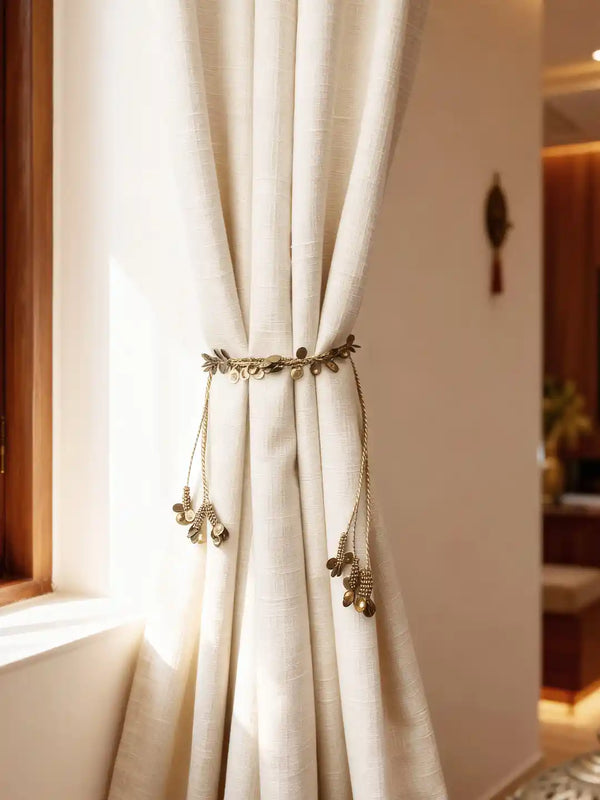 Regal Gilt brass-tone leaf and coin charm curtain tieback on cream linen