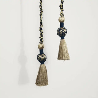 Close-up shot of the Regal Twist Tassel hanging, detailing the spherical knot with the navy blue caged netting and gold fringe.