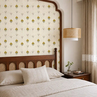 The Reva mustard sage wallpaper mural installed on a feature wall in a bedroom with a dark wood cane headboard and rattan pendant light view-bedroom