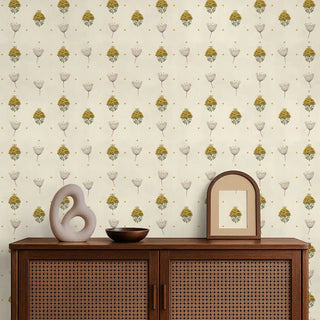 The Reva mustard sage wallpaper installed behind a rattan-front wood console styled with a sculptural object and framed art view-livingroom