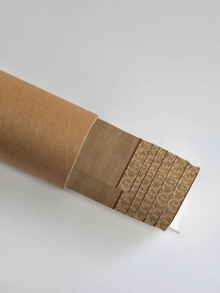 Premium protective packaging tube showing the rolled River Embrace print and its decorative border detail.