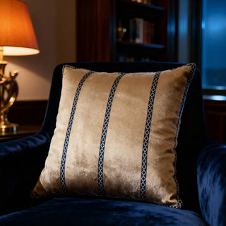 Single Riviera Band Cushion Cover displayed on a dark blue velvet armchair in a luxurious room.