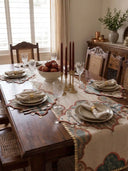 The Riwaayat embroidered table runner styled down a formal wooden dining table with brass candlesticks and burgundy taper candles.