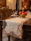 The Riwaayat block-printed linen table runner with gold coin borders styled under a brass bowl filled with pomegranates in a heritage dining room