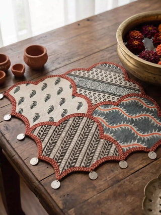 A detailed close-up shot highlighting the block-printed leaf bootis and neat braided borders of the Riwaayat luxury table mat.