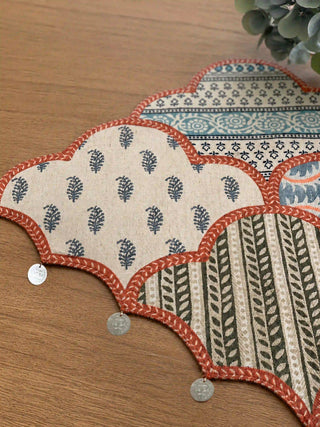 A high-resolution close-up of the hand-stitched silver sequins, block-printed motifs, and metallic coin fringe on the Riwaayat table runner.