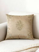 Rocaille Charm cushion cover in champagne satin displayed on a cream velvet armchair with gold corner embroidery.