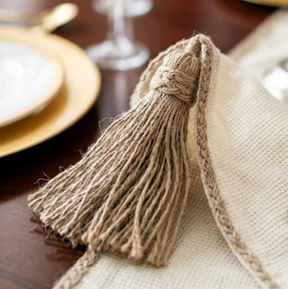 A detailed flat lay view of the corner design on the Rooted Grace placemat, showcasing the open-mesh border and embroidered twig.