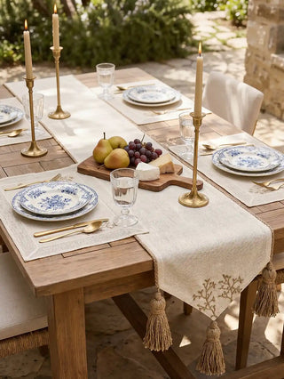 The Rooted Grace open-weave cream linen table runner styled for a sunny outdoor lunch banquet with blue and white porcelain plates.