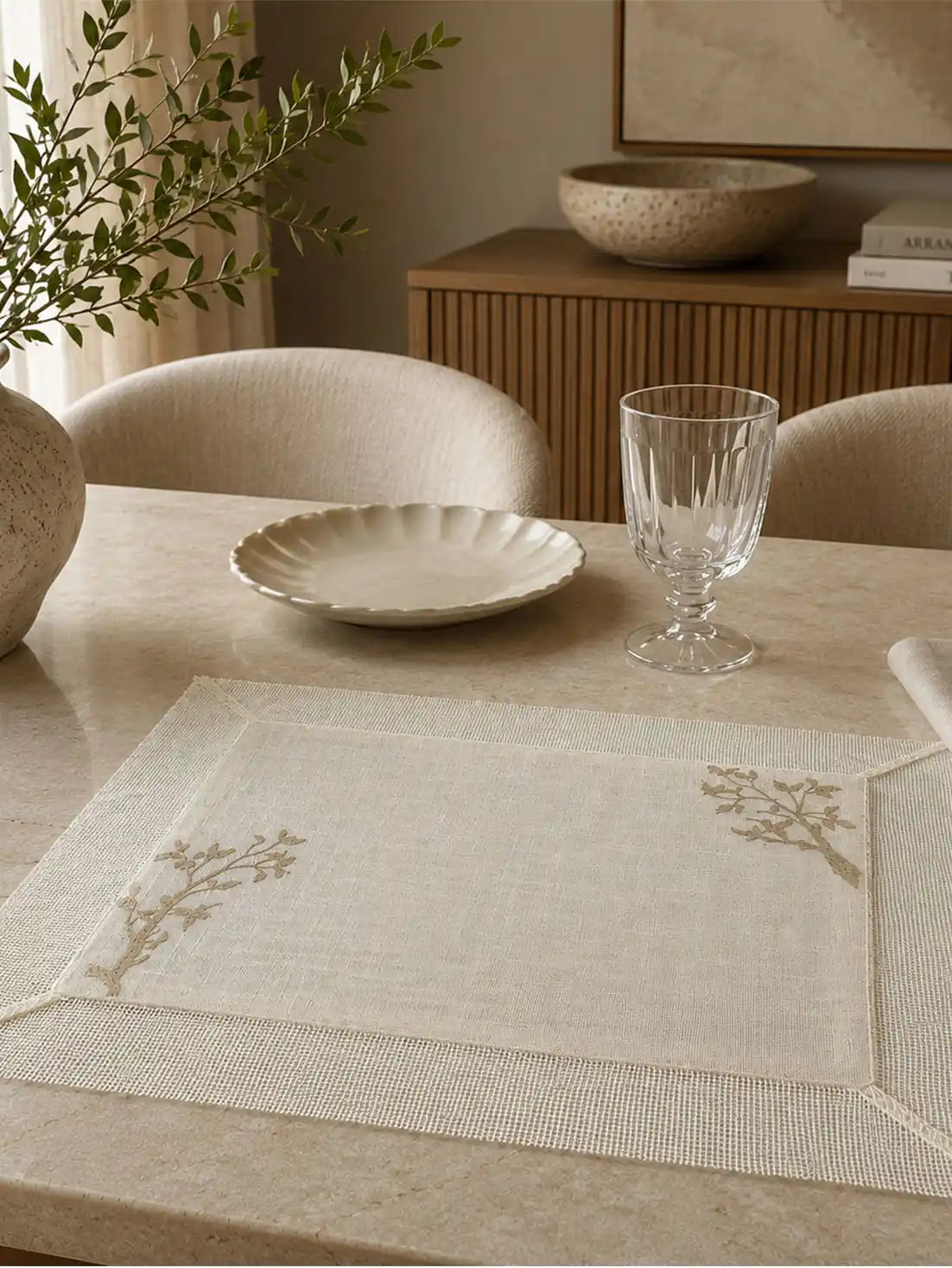 Open-weave linen runner and matching embroidered mats dressing a long outdoor table