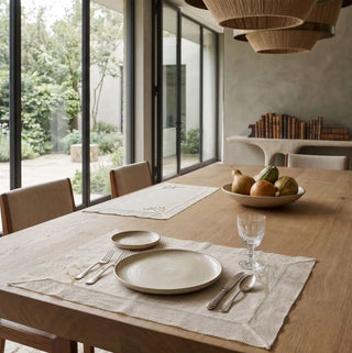 The Rooted Grace table runner and matching placemats styled across a luxury wooden tablescape with polished brass bowls.