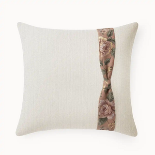 Rose Knot Cushion Cover: Front view of the cream textured pillow with a twisted vertical accent band featuring a floral rose print.