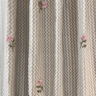 Close-up of Roselene Curtain fabric showing fine embroidery with zigzag weave and pink flowers.