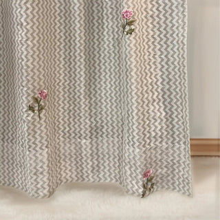 Hem detail of Roselene Curtain highlighting embroidered pink florals on soft textured fabric.