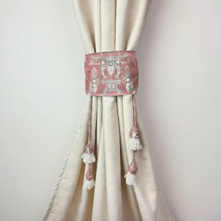 Rosette Royale Handcrafted Curtain Tieback secured on a cream curtain, featuring the dusty rose embroidered panel and white tassel fringe.