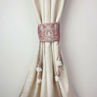 Rosette Royale Handcrafted Curtain Tieback secured on a cream curtain, featuring the dusty rose embroidered panel and white tassel fringe.