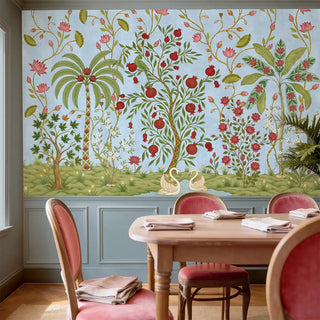 A luxury dining room featuring The Royal Bagh blue mural above grey wainscoting with pink velvet chairs.