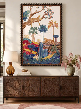 The Royal Jungle Safari wall art, portrait orientation, framed in a beaded wooden frame and hung above a dark wood sideboard with an amber glass lamp and a stoneware vase.
