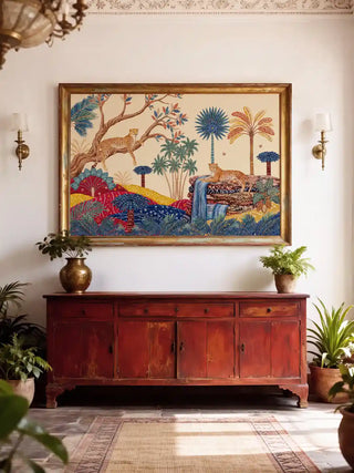 The Royal Jungle Safari wall art in a gilt frame above a distressed red Indian sideboard with brass urns and tropical plants in a white heritage foyer with plaster cornice and brass wall sconces