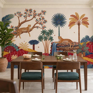 Royal Jungle Safari wallpaper behind a walnut dining table with four chairs in deep green upholstery, a ribbed glass carafe and a fiddle leaf fig in a terracotta pot.